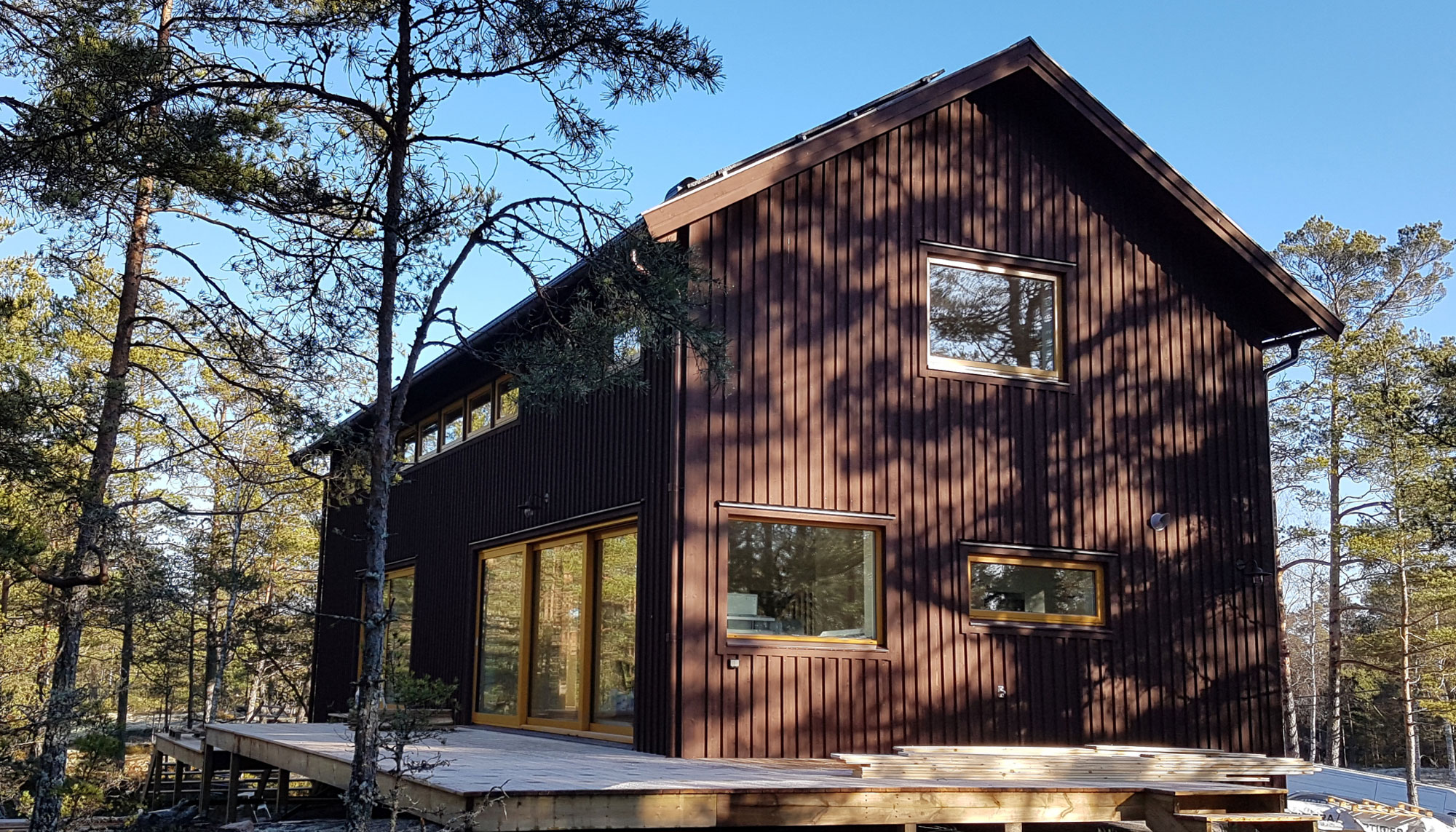 Hus med brun fasad byggt av HusEsset i en skog